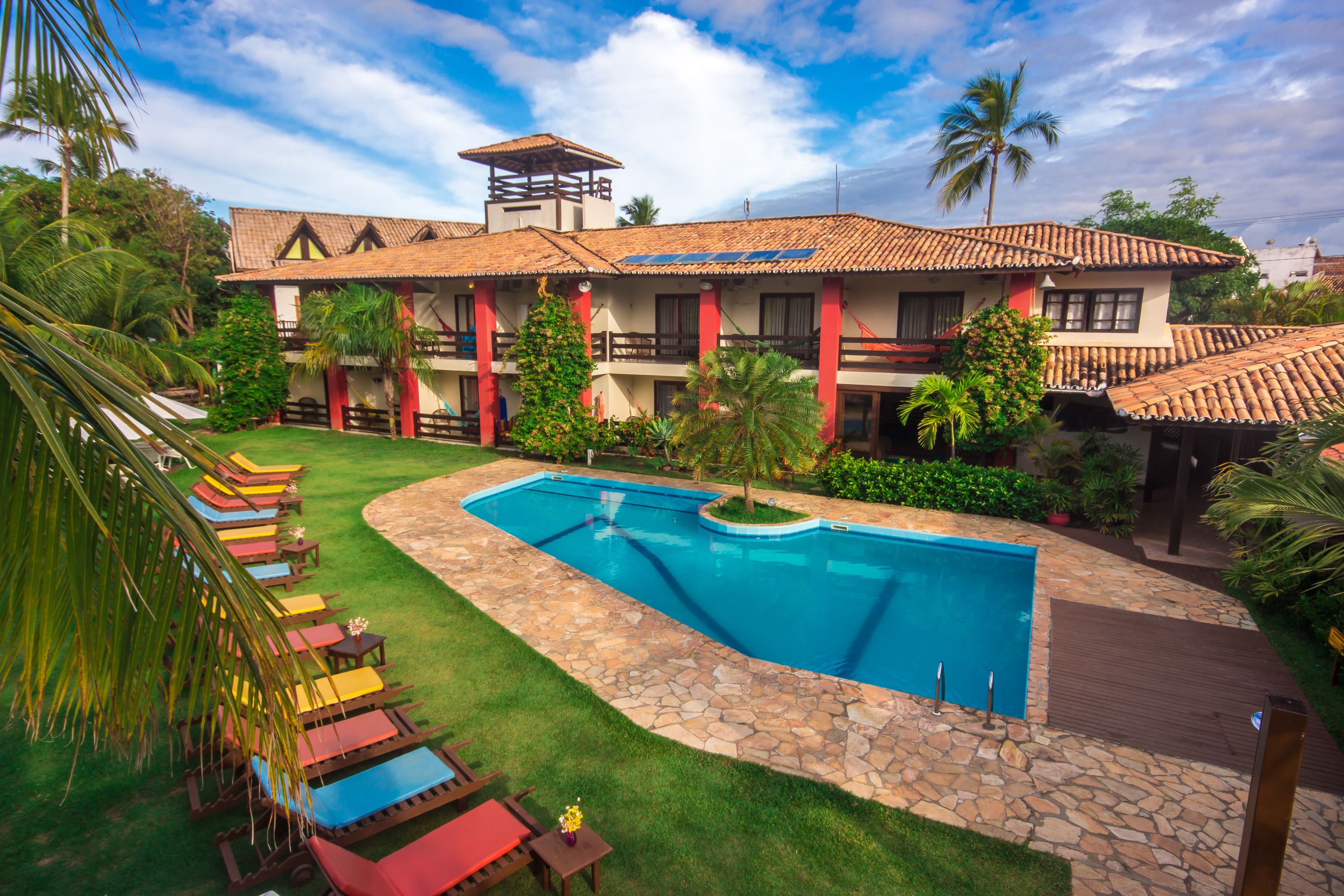 Ein Resort mit Schwimmbad, Liegestühlen und einem gepflegten Garten.
