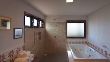 Un baño con bañera, ducha y tocador con toallas.