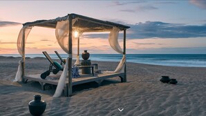 A beach cabana with a canopy, a table with chairs, and a large vase. - Zorah Beach Hotel (Trairi)