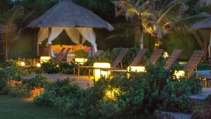 A resort with thatched-roof cabanas, lounge chairs, and well-lit pathways. - Zorah Beach Hotel (Trairi)