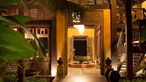 A hallway with a thatched roof, a central fountain, and bookshelves on the right. - Zorah Beach Hotel (Trairi)
