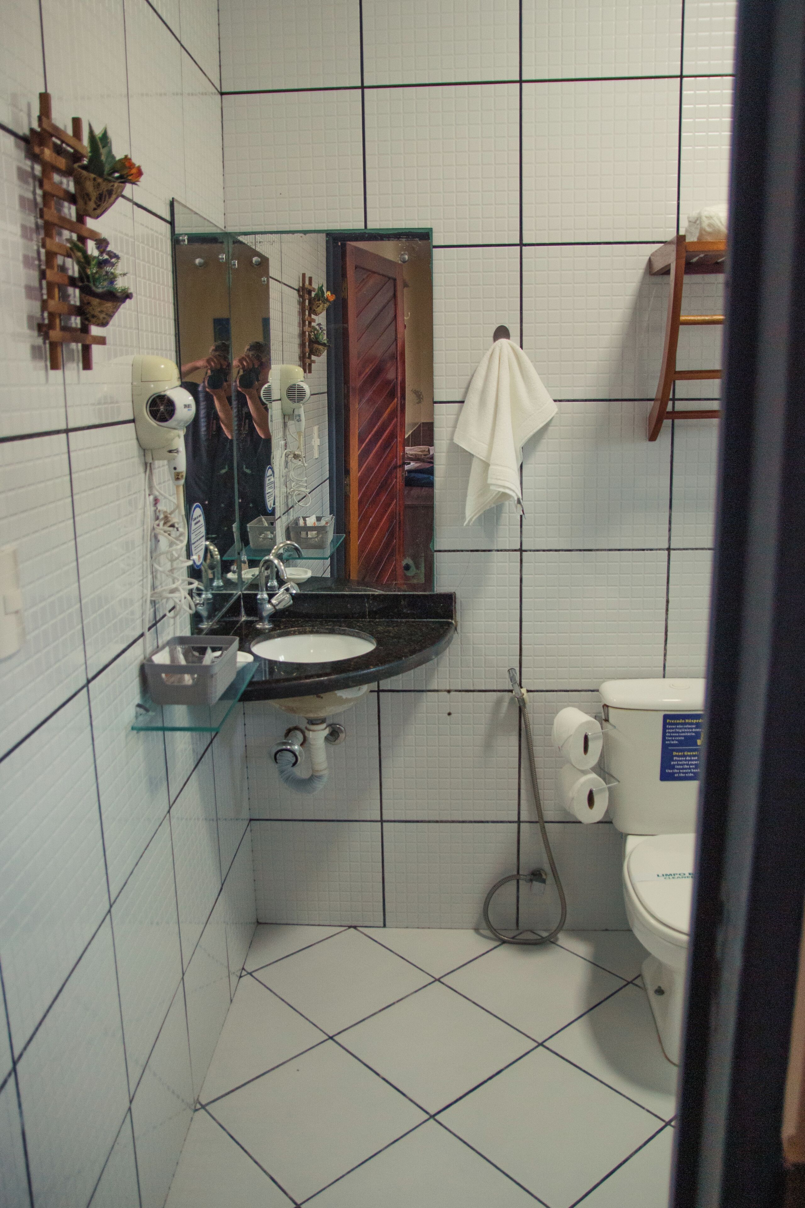 A bathroom with a sink, mirror, toilet, and shower.