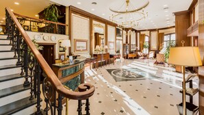 A grand lobby with a marble staircase, a chandelier, and a reception desk. - Gordion Hotel - Special Class (Ankara)