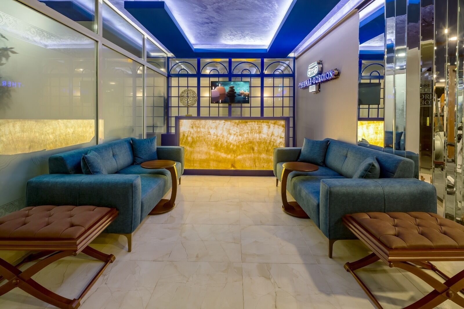 A modern lobby with two sofas, a coffee table, and a reception desk.