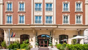 A large, red-brick building with a classic facade, multiple windows, and a prominent entrance with a sign reading "GORDION HOTEL". - Gordion Hotel - Special Class (Ankara)