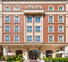A large, red-brick building with a classic facade, multiple windows, and a prominent entrance with a sign reading "GORDION HOTEL".