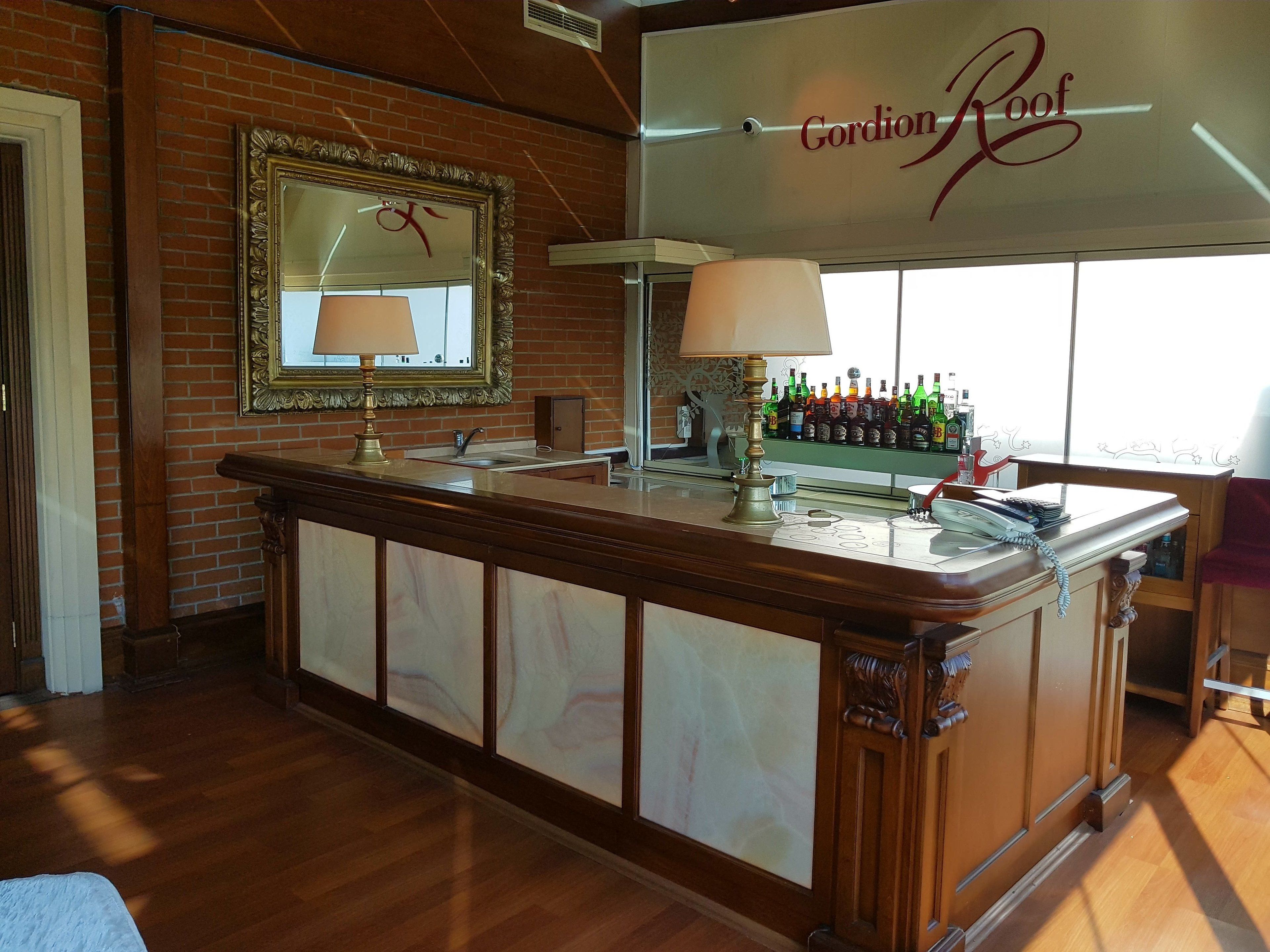 A bar area with a mirror, a lamp, and a minibar.