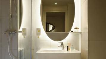 Ein Badezimmer mit Dusche, Waschbecken und Spiegel.