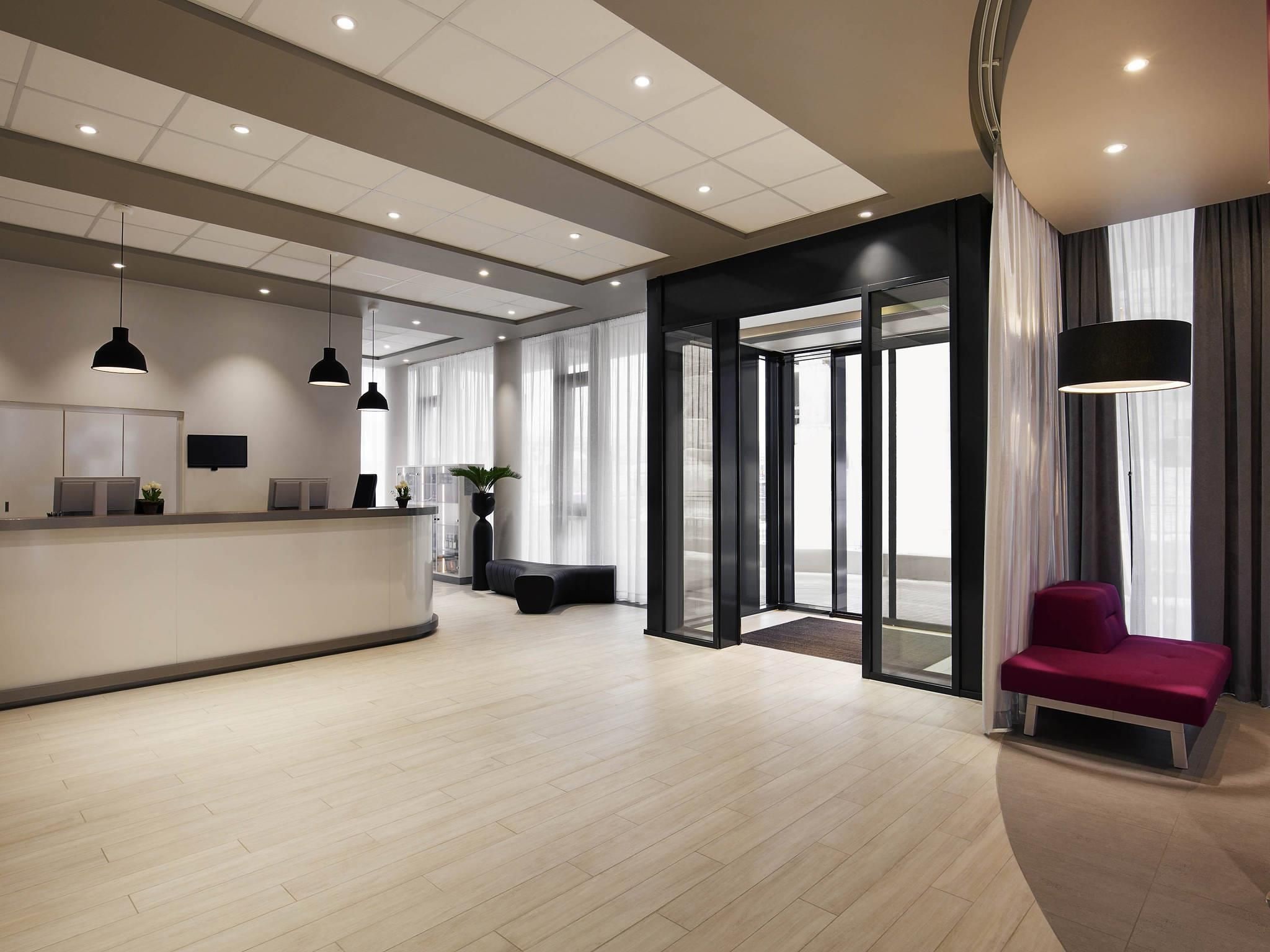 A modern reception area with a counter, seating, and a large glass door leading outside.