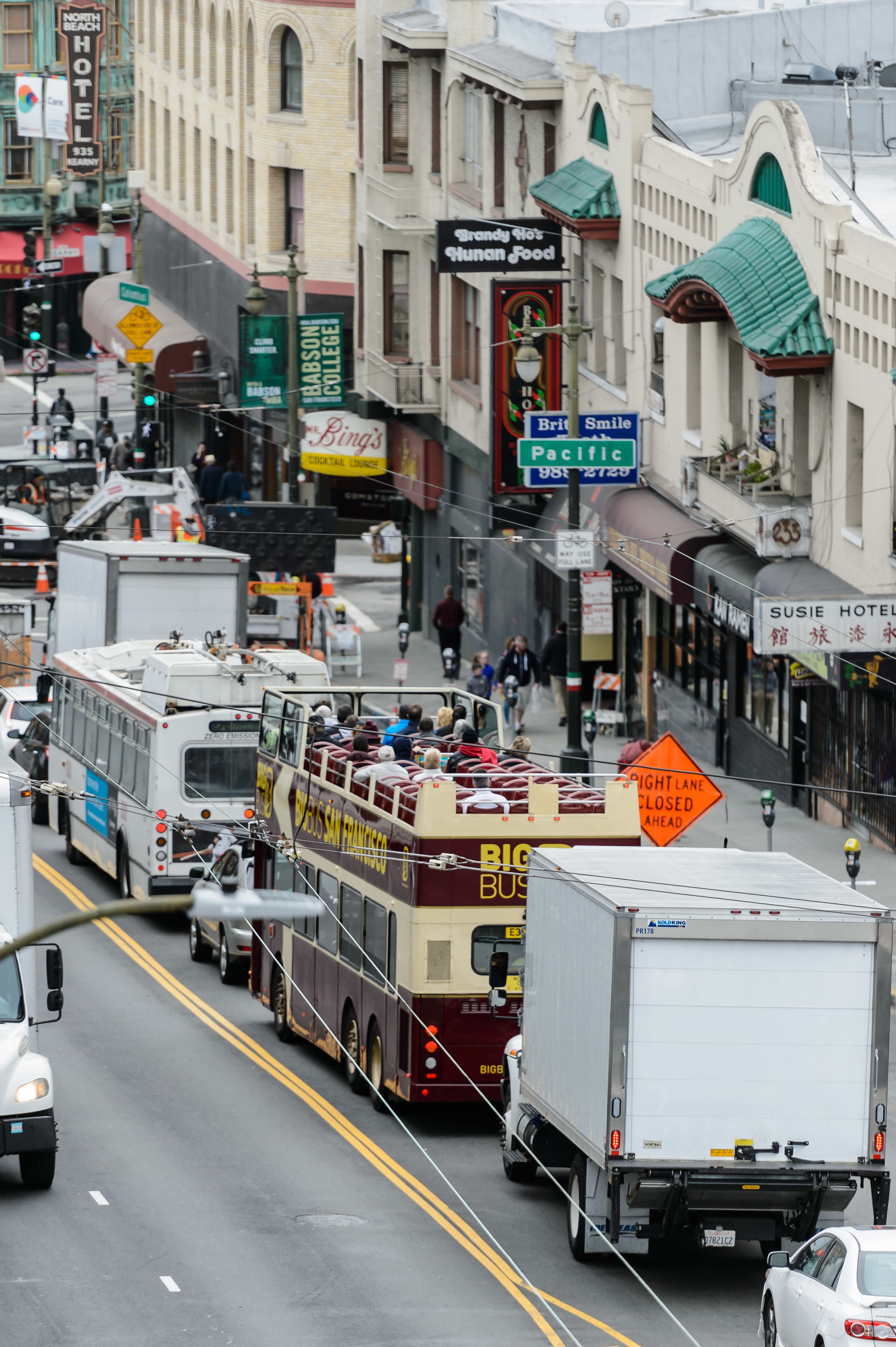 A street scene with a double-decker bus, a white truck, and a white car.