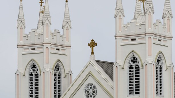 A white church with multiple spires and crosses, large arched windows, and a clock. - Europa Hotel (San Francisco)