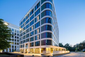 Un hôtel moderne, avec plusieurs étages, de grandes fenêtres et une enseigne bien visible.