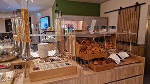 Een buffetopstelling met verschillende soorten eten en bestek.