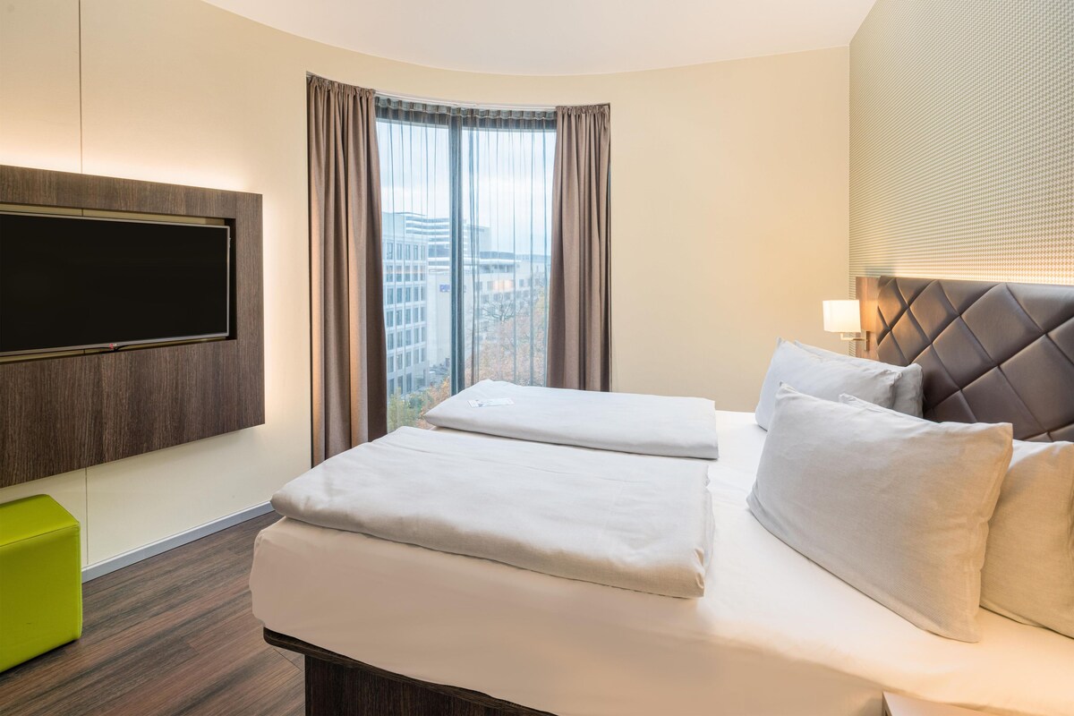 Luxe beddengoed, een kluis op de kamer, een bureau, een laptopwerkplek