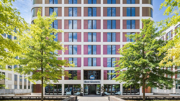 Un hôtel à plusieurs étages doté d’une façade moderne, de grandes fenêtres et d’une enseigne bien visible indiquant « Best Western ».