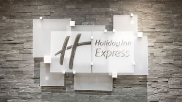 A Holiday Inn Express sign on a stone wall.