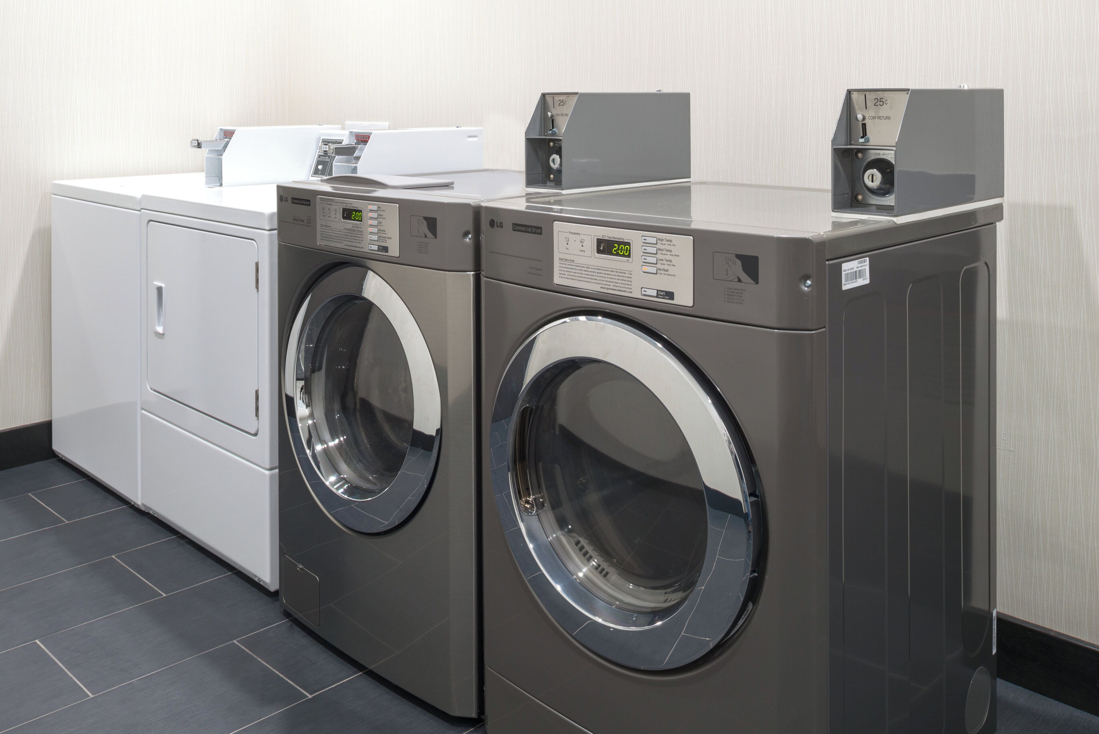 A laundry area with two front-loading washers and a dryer.