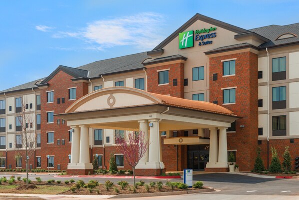 A Holiday Inn Express hotel with a brick facade, a covered entrance, and a landscaped front yard. - Holiday Inn Express & Suites Norman by IHG (Norman)