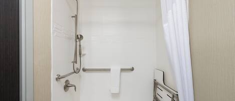 A shower with a grab bar, a towel rack, and a shower curtain.