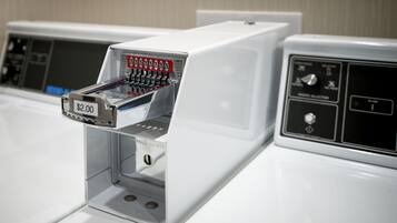 Lavadora blanca con etiqueta de precio de 2,00 dólares, un selector de tela y un panel de control con varias opciones.