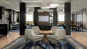 A modern lobby with a round table, two armchairs, and pendant lighting. - Fairfield Inn & Suites Riverside Corona/Norco (Norco)