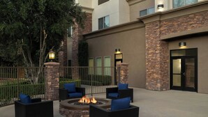 An outdoor seating area with wicker furniture and a central fire pit. - Fairfield Inn & Suites Riverside Corona/Norco (Norco)