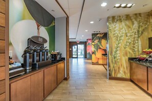 Une cuisine moderne dotée d’un coin café, de meubles en bois et d’une fresque représentant des fleurs et des épis de blé.