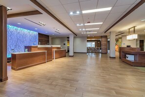 A spacious lobby with wooden flooring, a reception desk, and a wall with a blue abstract pattern. - Fairfield Inn & Suites Elkhart (Elkhart)