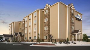 A multi-story hotel with a stone facade and a sign reading "MICROTEL BY WYNDHAM'S". - Microtel Inn & Suites By Wyndham Lynchburg (Lynchburg)