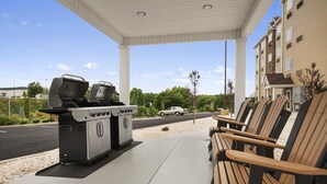 An outdoor barbecue area with a grill and seating. - Microtel Inn & Suites By Wyndham Lynchburg (Lynchburg)