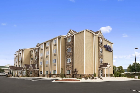 A multi-story hotel with a stone facade, a covered entrance, and a sign indicating it is a Microtel by Wyndham.
