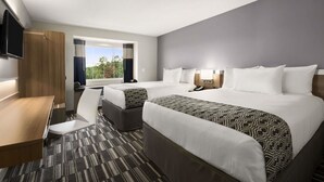 A hotel room with two beds, a desk, a chair, a TV, and a window with curtains. - Microtel Inn & Suites By Wyndham Lynchburg (Lynchburg)