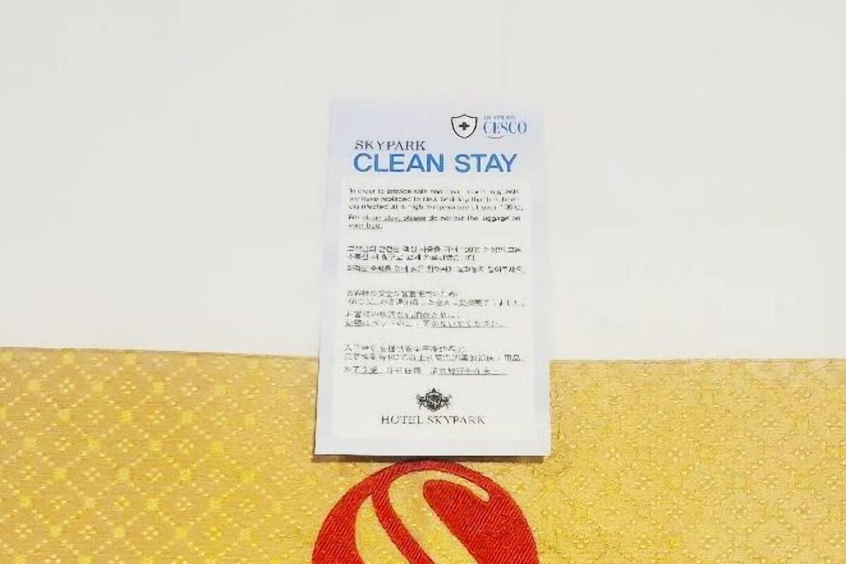 Une enseigne d’hôtel avec un logo rouge et jaune et l’inscription « HÔTEL SKYPARK ».