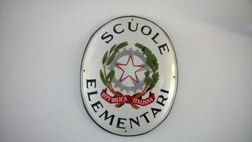 A circular emblem with the text "SCUOLE ELEMENTARI REPUBBLICA ITALIANA" and a star in the center.