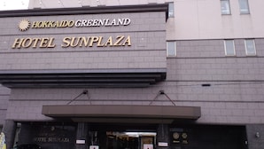 L’extérieur de l’hôtel Hokkaido Greenland Hotel Sunplaza, avec son entrée imposante et son panneau indicateur bien visible.