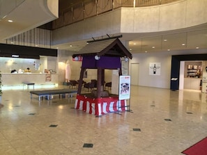 A spacious lobby with a central seating area, a reception desk, and a signboard. - Hokkaido Greenland Hotel Sunplaza (Iwamizawa)