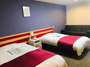 A hotel room with two beds, a sofa, a nightstand, and a wall-mounted picture. - Hokkaido Greenland Hotel Sunplaza (Iwamizawa)