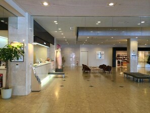 A spacious lobby with a reception desk, seating area, and a coffee bar. - Hokkaido Greenland Hotel Sunplaza (Iwamizawa)