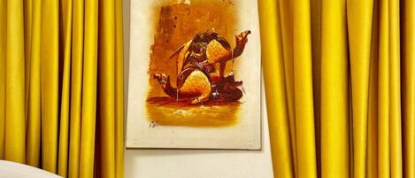 Una pintura de un camello en una pared, rodeada de cortinas amarillas.