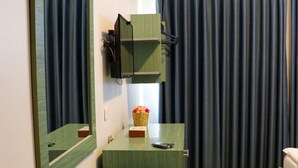Un baño moderno con tocador de madera, un espejo grande y zona de ducha.