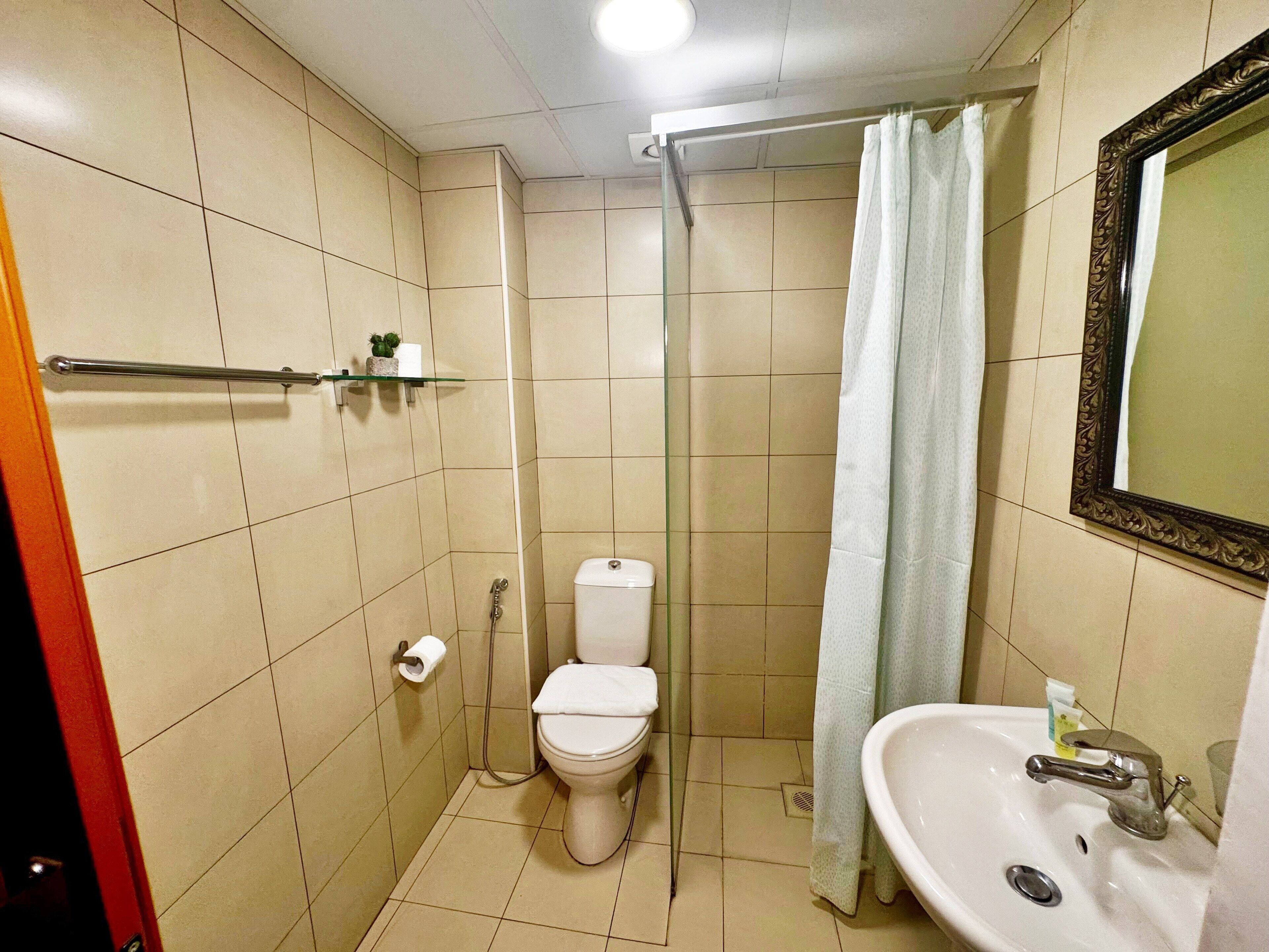 Ein kleines Badezimmer mit Toilette, Dusche und Waschbecken.