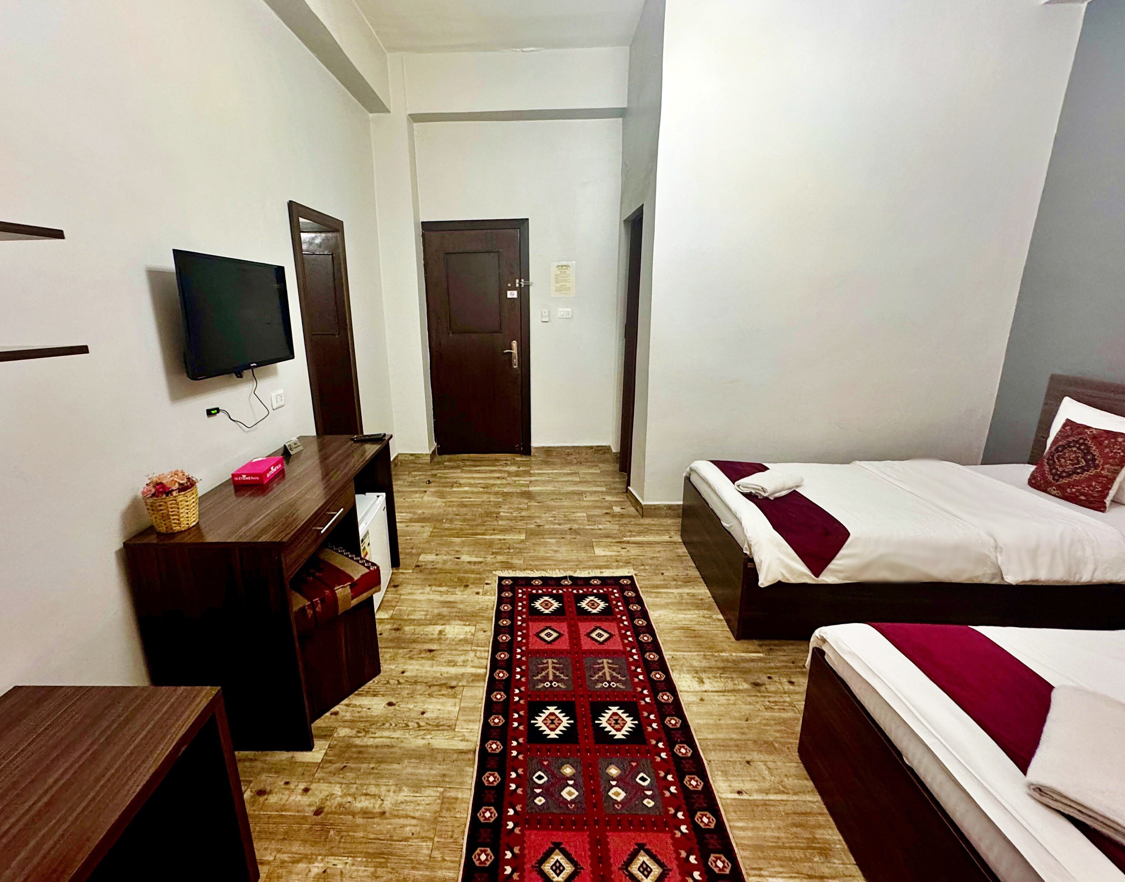 Une chambre d’hôtel comprenant un lit, un bureau, une télévision et une porte donnant sur une autre pièce.