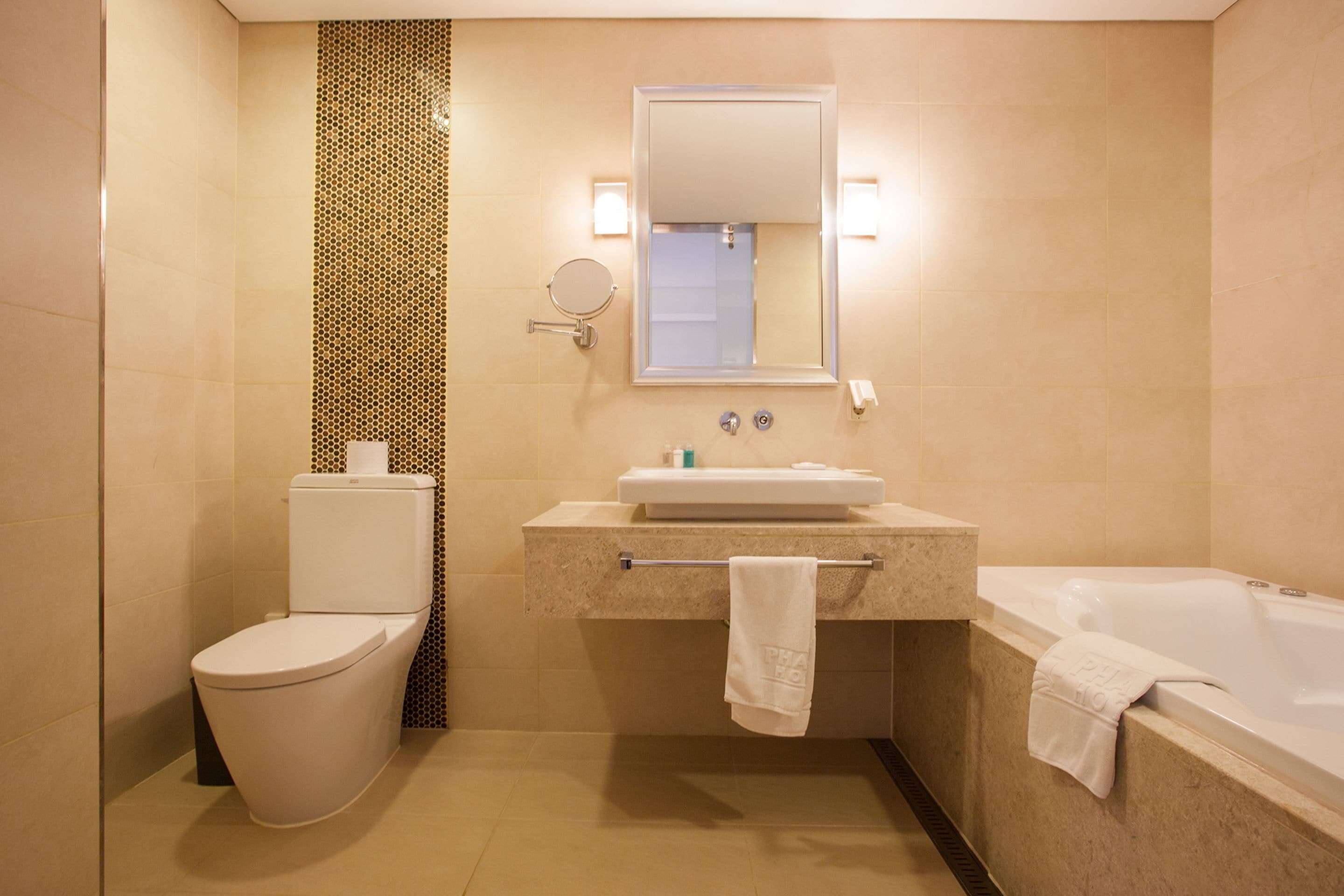 Een badkamer met toilet, wastafel en bad.