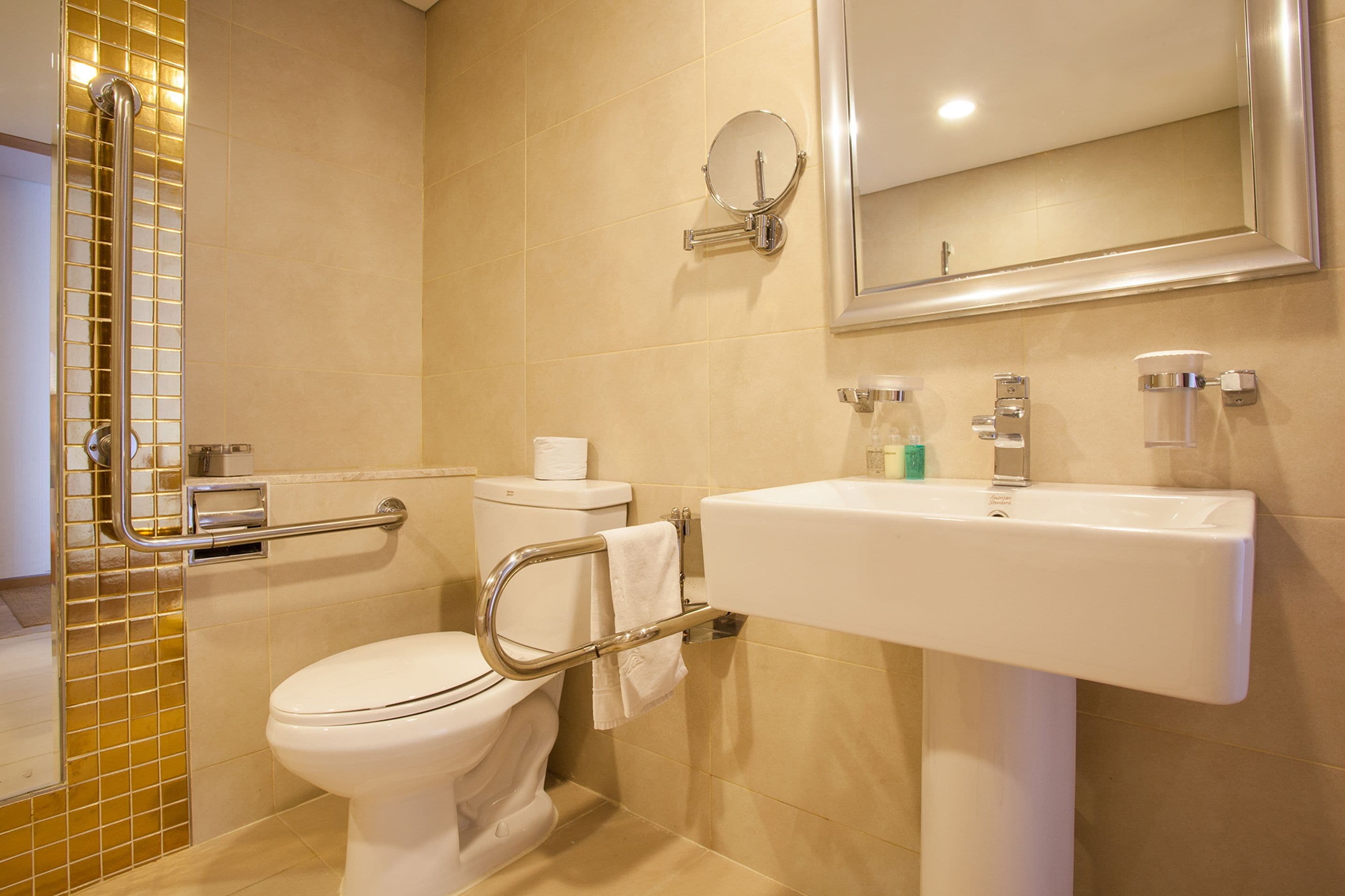 A modern bathroom with a toilet, sink, and mirror.