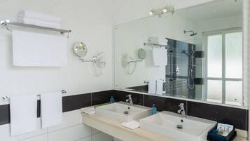 Un baño moderno con dos lavabos, un espejo grande y un perchero para toallas.