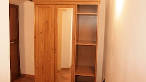 A wooden wardrobe with multiple shelves and a door. - Sixtythree Guesthouse (Rome)