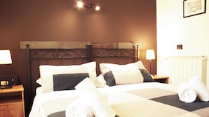 A neatly made bed with pillows and rolled towels, a bedside table with a lamp, and a wall-mounted picture. - Sixtythree Guesthouse (Rome)