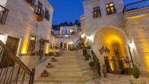 A historic building with a grand staircase, multiple balconies, and a central archway. - Magic Cave House (Ürgüp)