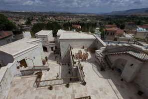 Un patio con un espacio central abierto, rodeado de edificios, que cuenta con una escalera y una pequeña zona de estar.