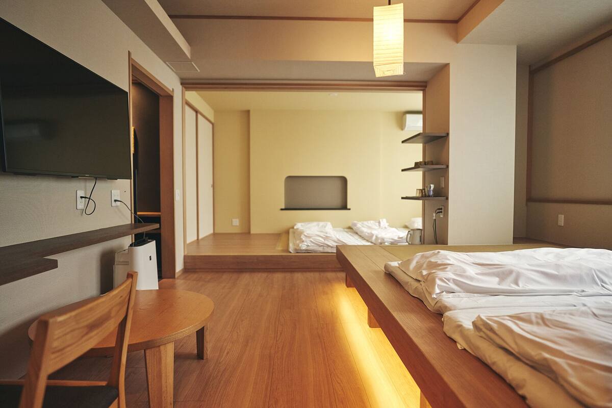 Ein Hotelzimmer mit einem Bett, einem Schreibtisch, einem Stuhl, einem Fernseher und einem Regal.